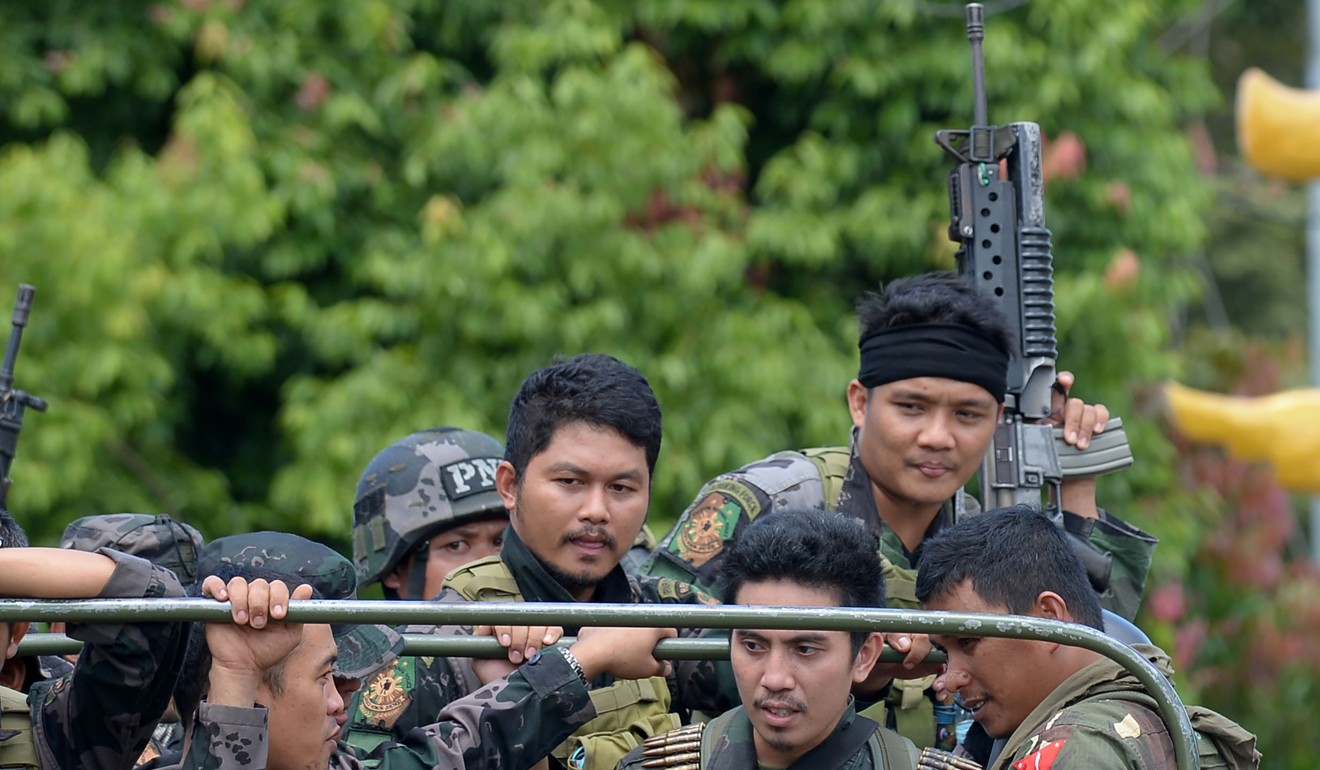 Members of the Philippine police special action force ride in an army truck on their way to the frontline. Photo: AFP