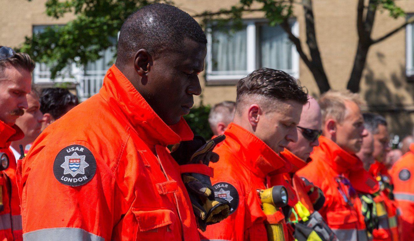 Members of the London Fire Brigade and emergency services observe a minute silence outside Notting Hill Methodist Church for the victims of the Grenfell Tower Fire in London. Photo: Xinhua