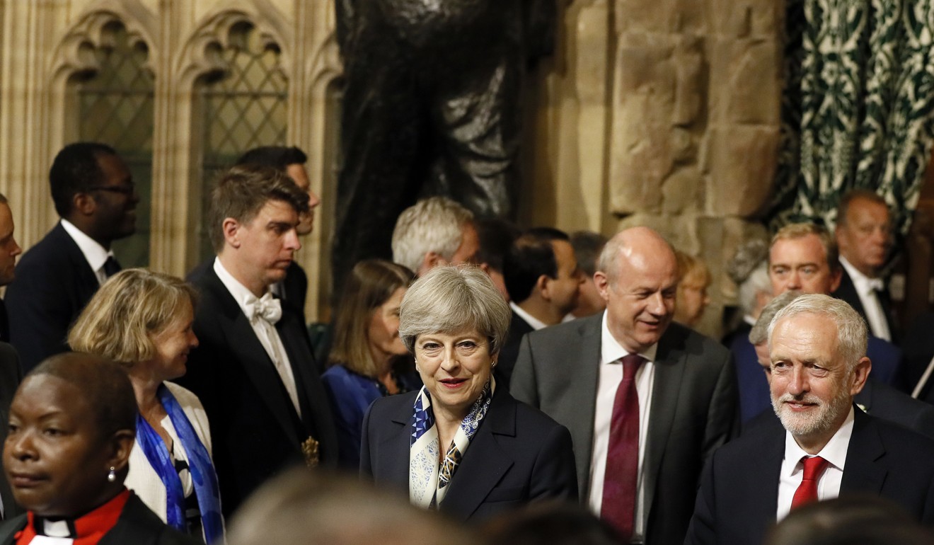 Britain's Prime Minister Theresa May, centre, and leader of the opposition Jeremy Corbyn, right, walk through the House of Commons to attend the state opening of Parliament in London. Photo: AP