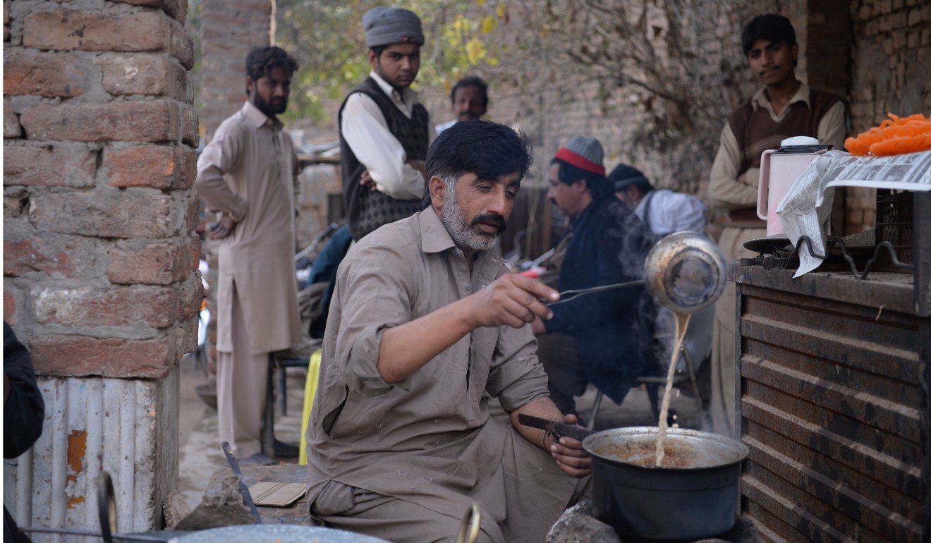 Malik Zafar Iqbal, who runs the Association of Kidney Sellers, makes tea for customers at his stall in the town of Kot Momin in Sargodha District, Punjab province. Photo: AFP