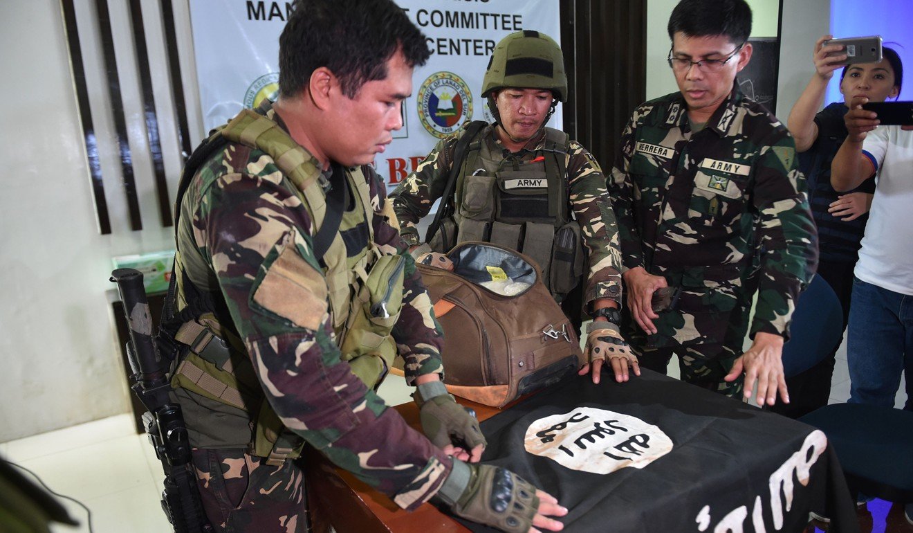 Philippine army personnel prepare to display an Islamic State flag and illegal drugs recovered from a militant position, ahead of a press conference in Marawi, Mindanao, on June 19. Photo: AFP