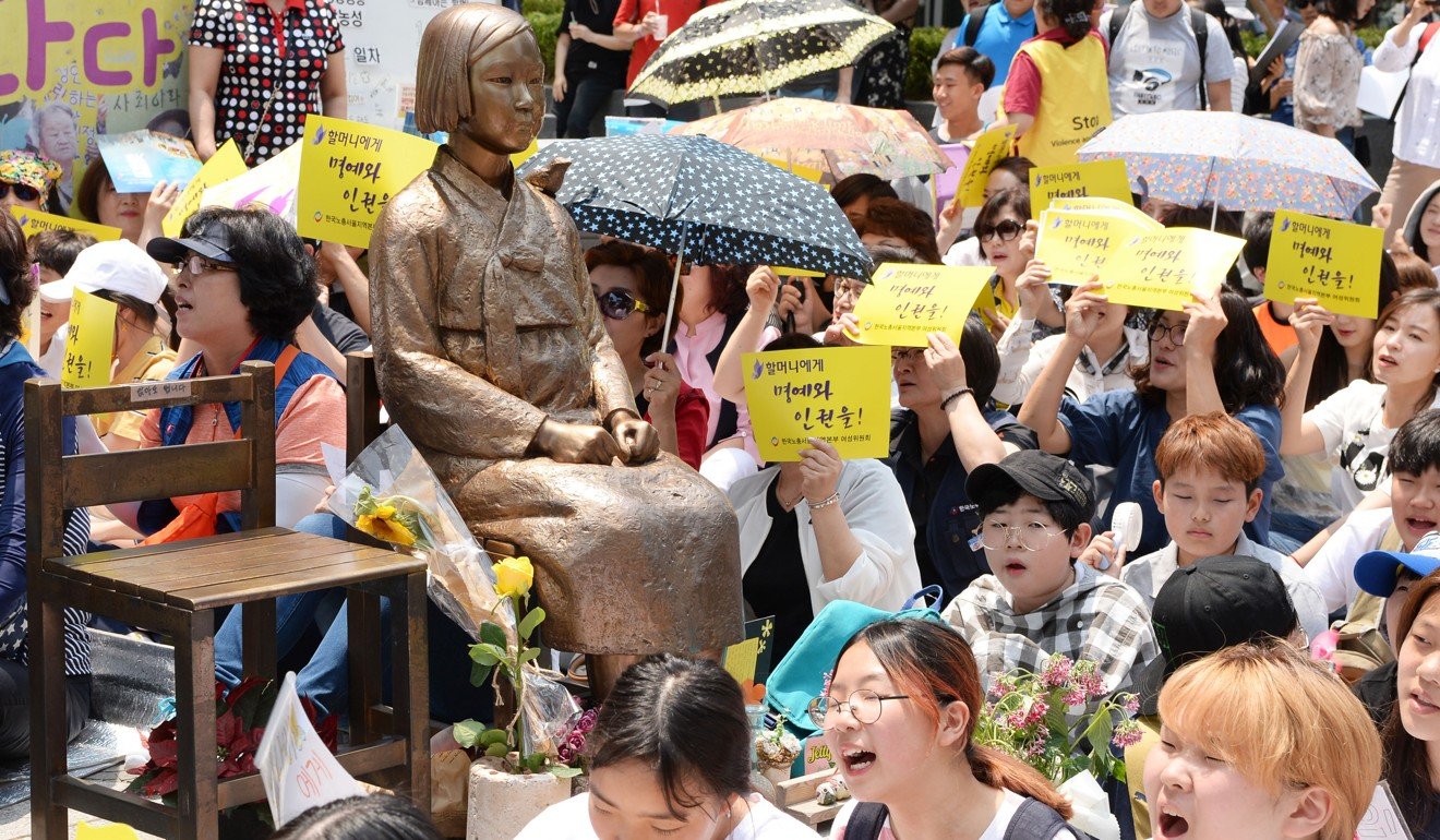 Opponents of the 2015 agreement between Seoul and Tokyo on the issue of Korean “comfort women”, who were forced to work in wartime Japanese military brothels, rally around a bronze statue of a young girl symbolising such women, near the Japanese embassy in Seoul on June 21. Photo: Kyodo