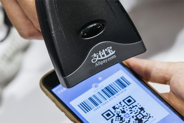 An employee scans a QR code displayed on the Alipay app developed by Ant Financial Services Group, an affiliate of Alibaba Group Holding, inside a Sa Sa International Holdings store. Photo: Bloomberg