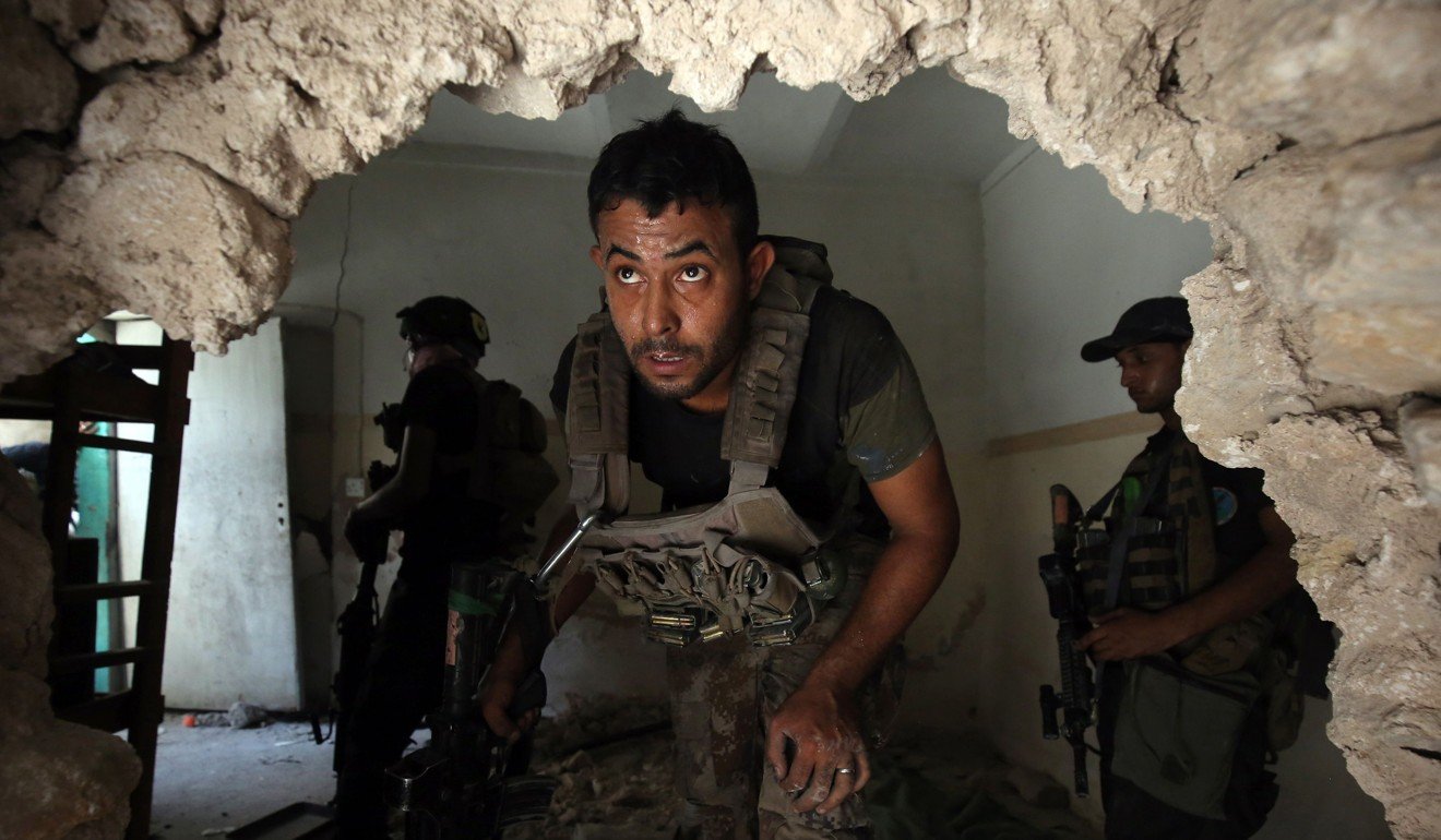 Iraqi Counter-Terrorism Service (CTS) troops advance inside a house in the Maidan district in Mosul's Old City on July 4, 2017, as they clear out Islamic State fighters holed out in the city. Photo: AFP