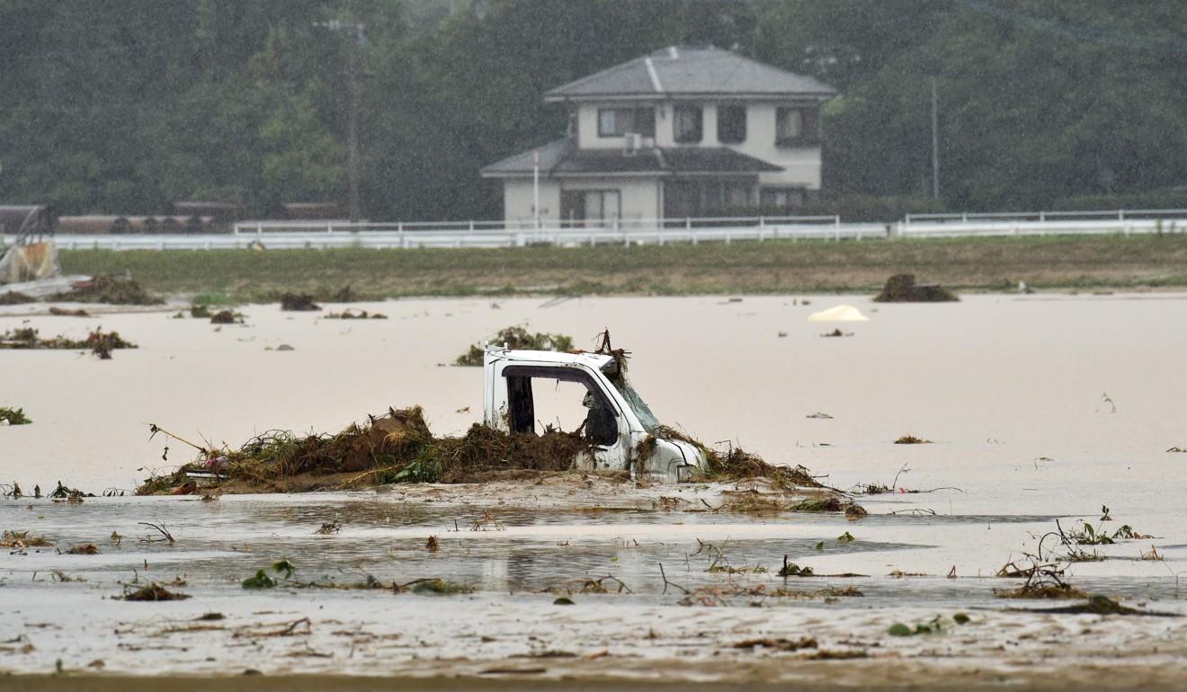 A vehicle inundated by floodwaters Asakura. Photo: AFP