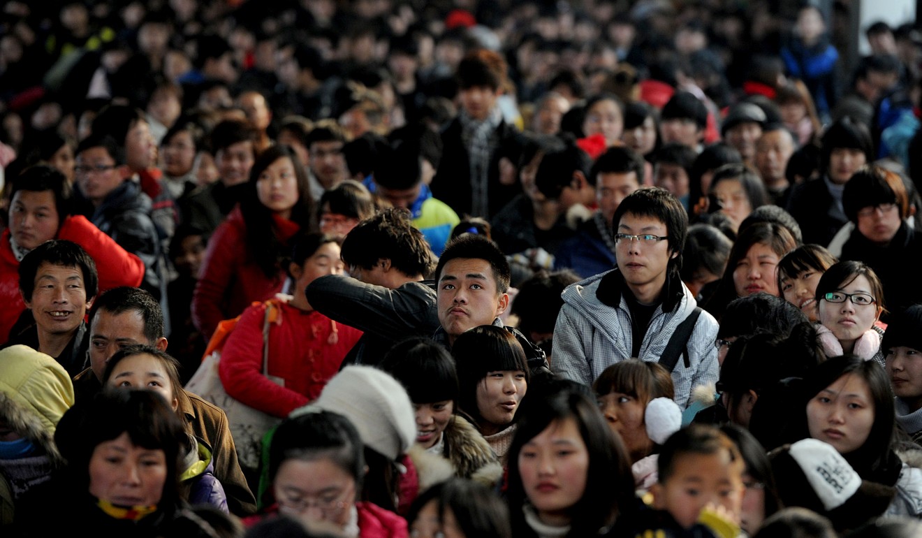 Passengers queue up to buy train tickets at a railway station during the Lunar New Year holidays in Hefe. Photo: AFP