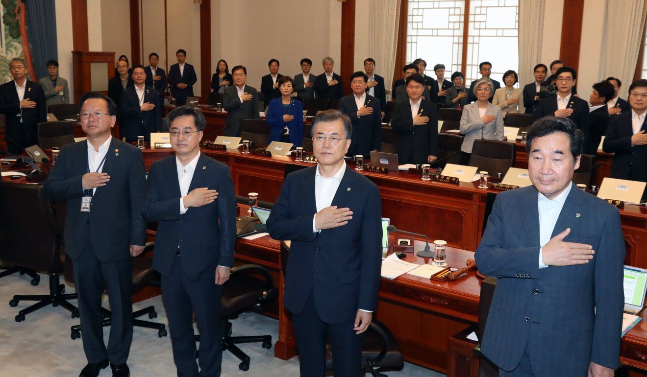 South Korean President Moon Jae-in salutes the national flag prior to the first meeting of his cabinet, 48 days after his inauguration. Photo: EPA