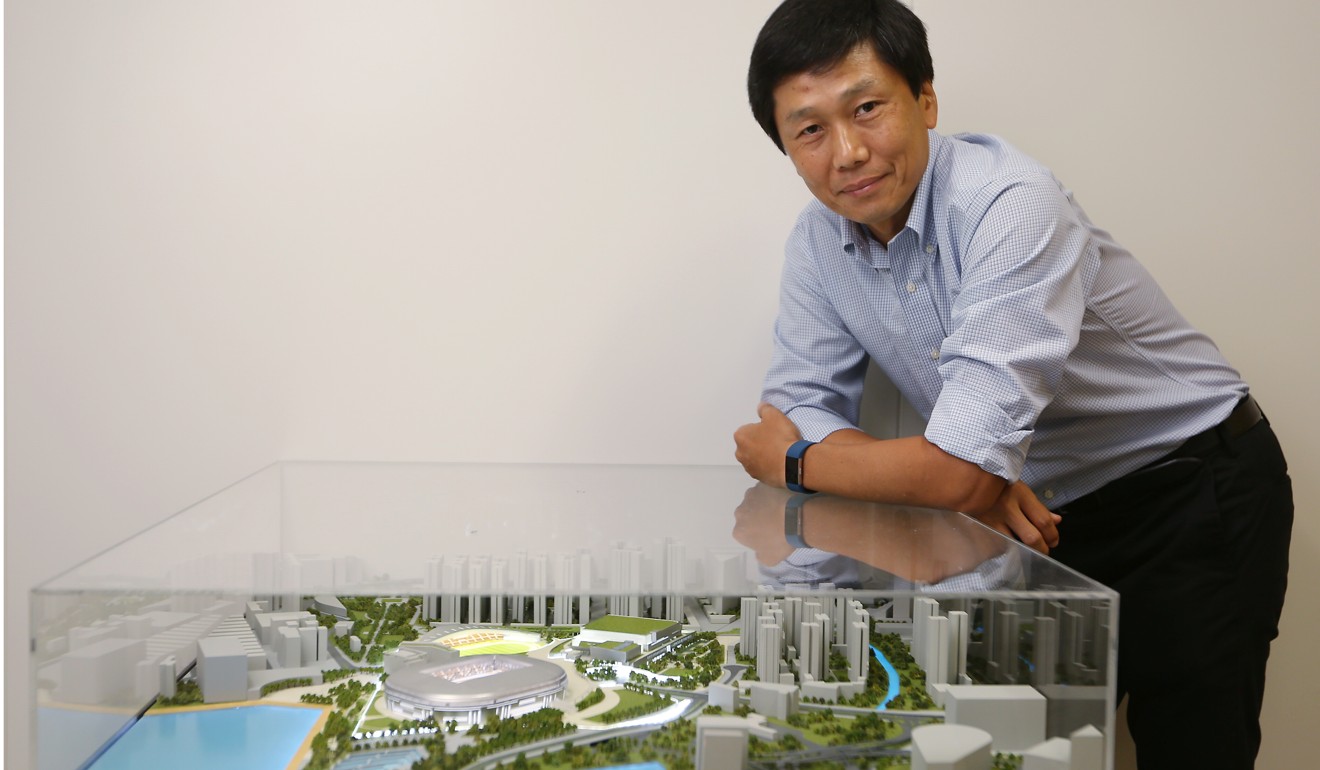 Yeung Tak-keung, the commissioner for sports, poses with a model of the Kai Tak Sports Park complex, in Tamar on May 26. Yeung has assured the public that the controversial project will not be a white elephant. Photo: Xiaomei Chen