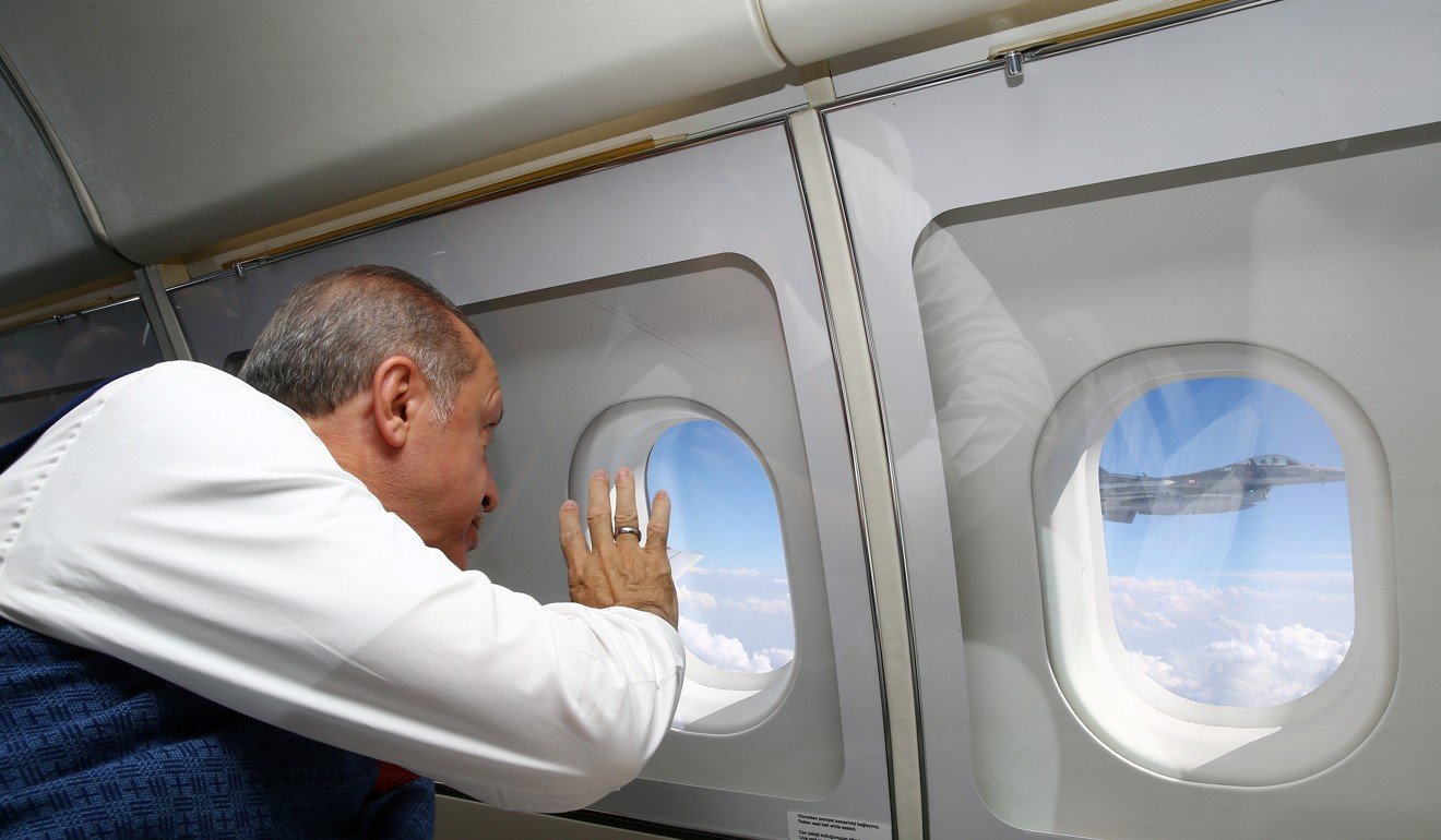 Turkish President Recep Tayyip Erdogan waves to a Turkish Air Force F-16 jet escorting his aircraft during his flight from Ankara to Istanbul to attend a ceremony marking the anniversary. Photo: Reuters