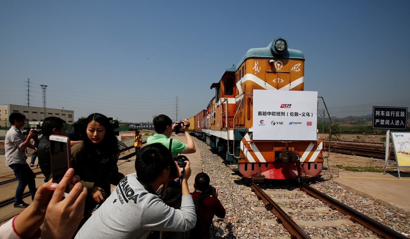 People take pictures as a train carrying containers from London arrives at the freight railway station in Yiwu, Zhejiang province, in China. Photo: Reuters