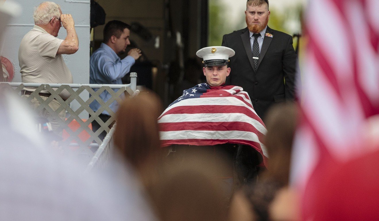 The flag-draped coffin carrying Cena is carried away by Lance Corporal Jeff DeYoung. Photo: AP