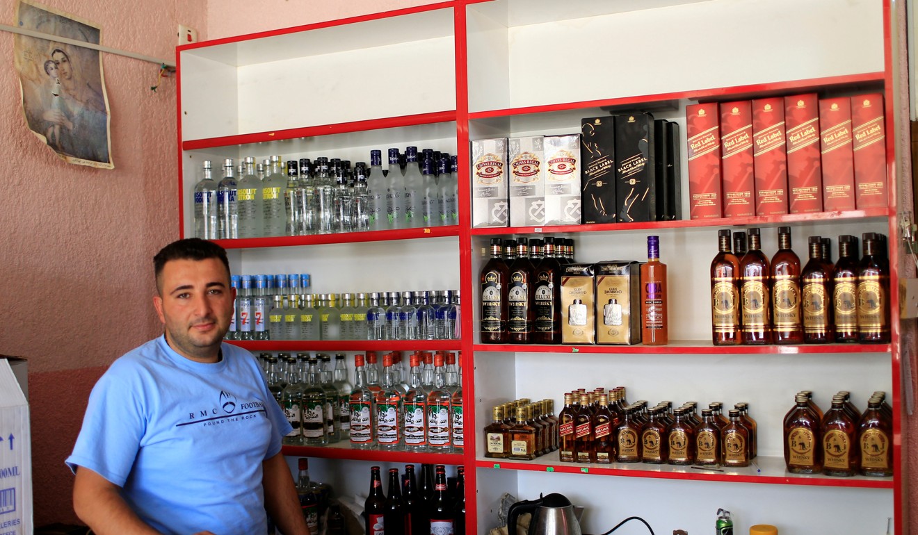 A liquor store owner waits for customers in his store in the town of Qaraqosh, south of Mosul. Photo: Reuters