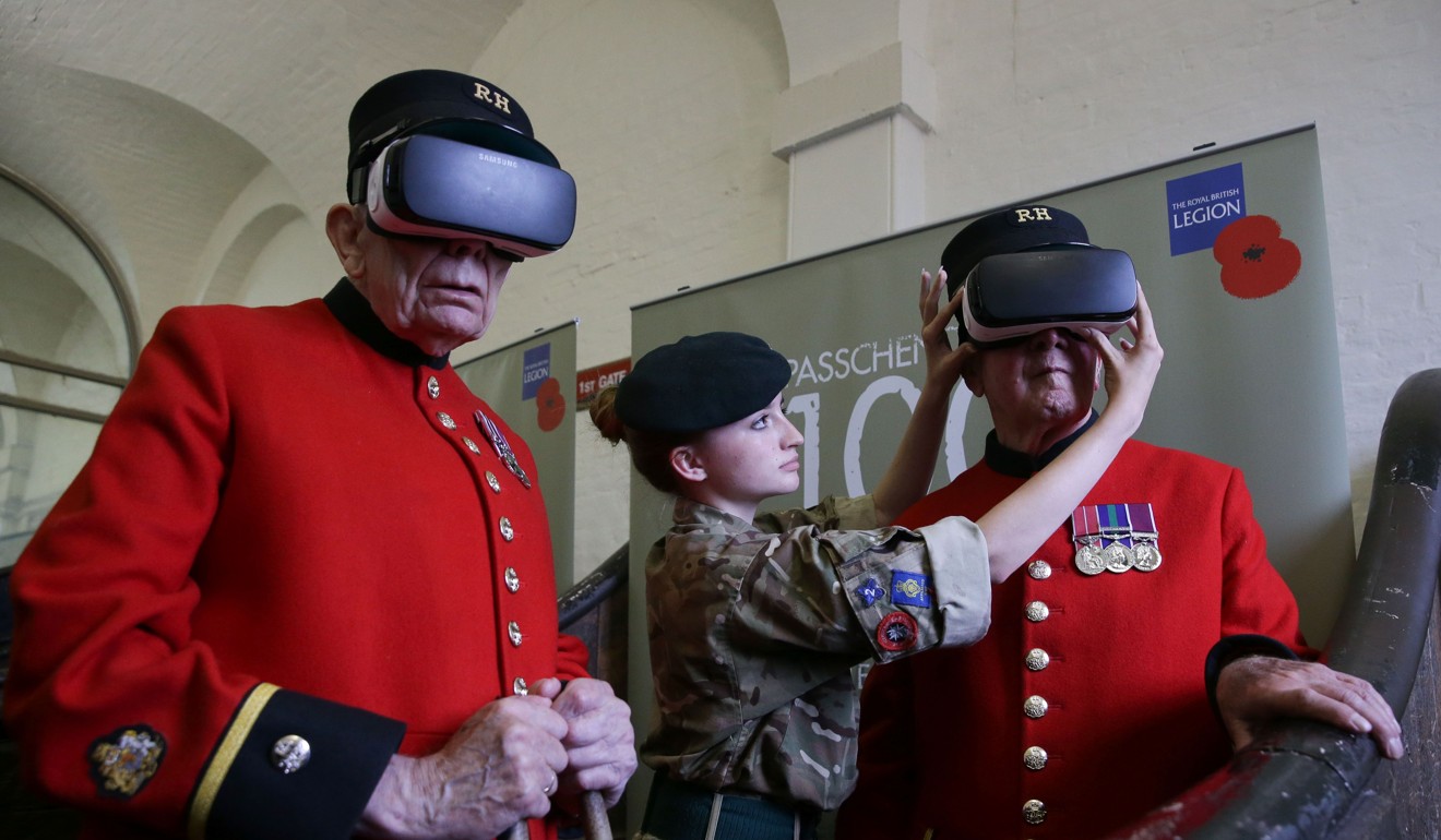 Cadet Maisie Jackson (C) adjusts a Virtual Reality headset for Chelsea pensioners Bill 'spud' Hunt, 83, (R) as Chelsea pensioner John Kidman, 87, looks on during the Royal British Legion launch of the Battle of Passchendaele virtual reality content at the Household Cavalry Museum in Westminster, central London. Photo: AFP