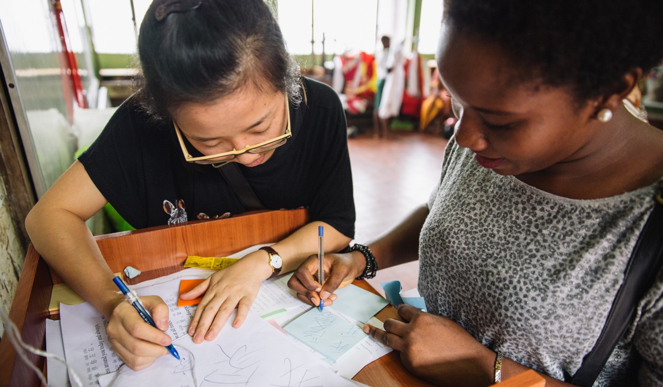 A local student, right, learns to write ‘I love my home’ in Chinese at the Confucius Institute of the University of Lagos in Nigeria. Photo: Xinhua