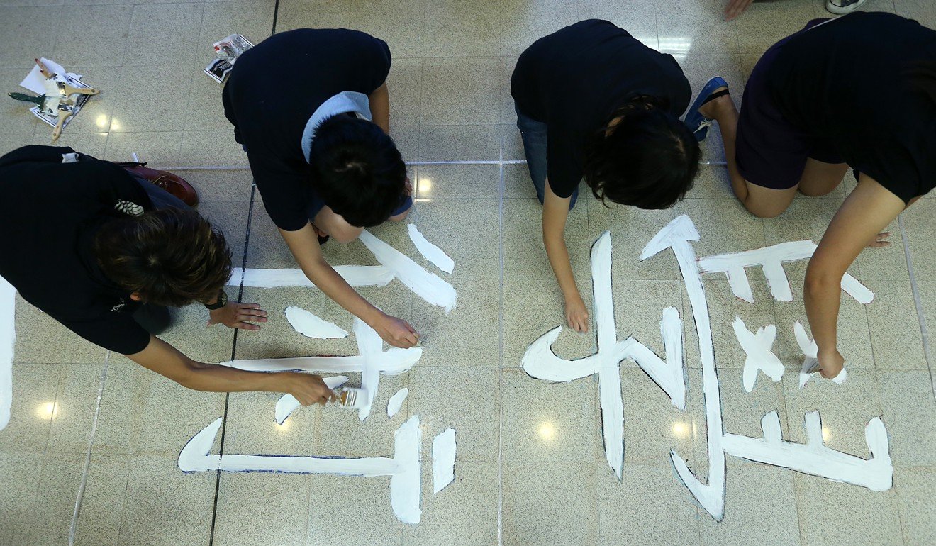 City University students write a message on the floor amid protests in 2012 accusing the government of trying to “brainwash” youngsters. Photo: Sam Tsang