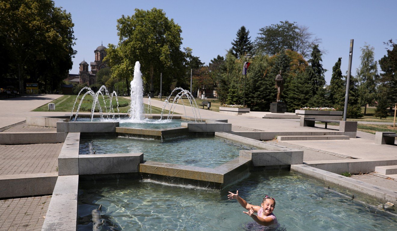 A girl cools off in a fountain at Tasmajdan park in Belgrade, Serbia. Photo: Reuters