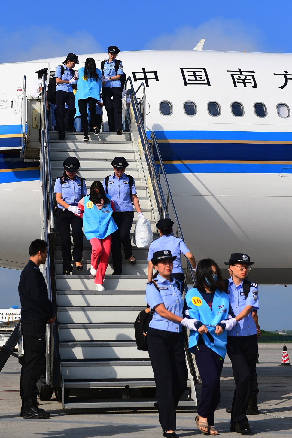The fraud suspects pictured getting off their plane at Changchun airport. Photo: Xinhua