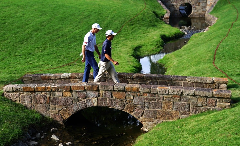 Kevin Kisner walks across the 13th hole bridge during with Jim Furyk. Kisner is joint-leader after the first round. Photo: AFP