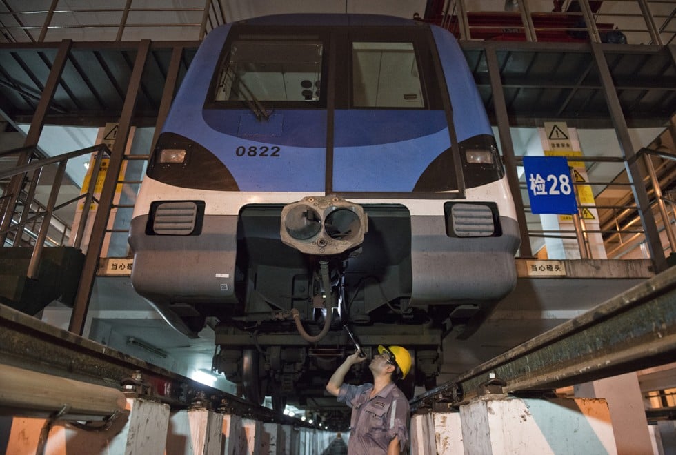 Tang Jinrong inspects a train in the Line 8 garages.