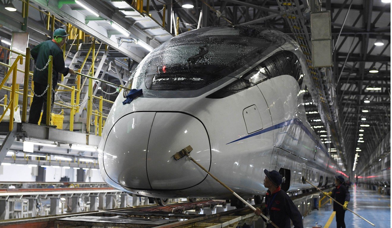 Workers clean a bullet train at a maintenance centre in Chongqing. China has been on a high-speed railway building spree for over a decade. Photo: AFP