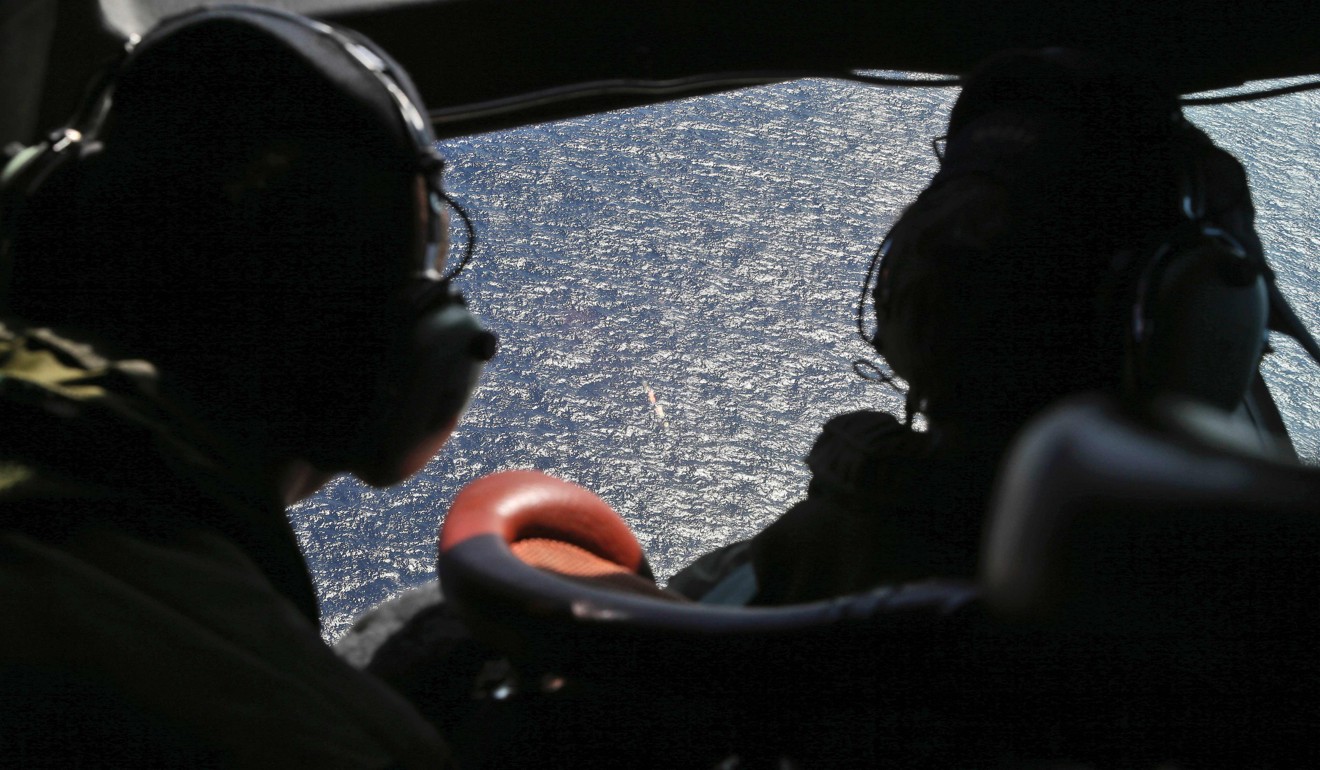 Crew members looking out the cockpit windows of a RNZAF P3 Orion during search operations for wreckage and debris of missing Malaysia Airlines Flight MH370 in the southern Indian Ocean. Photo: AFP