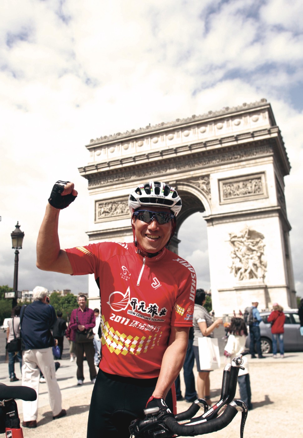 Chen punches the air at the Arc de Triomphe after a bike ride through Paris. Photo: Handout