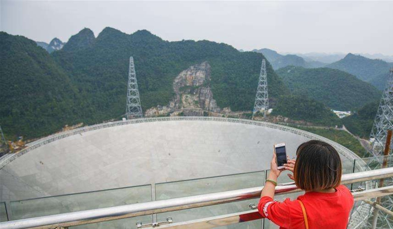A tourist snaps a photo of the Fast telescope in Guizhou. Photo: Handout.