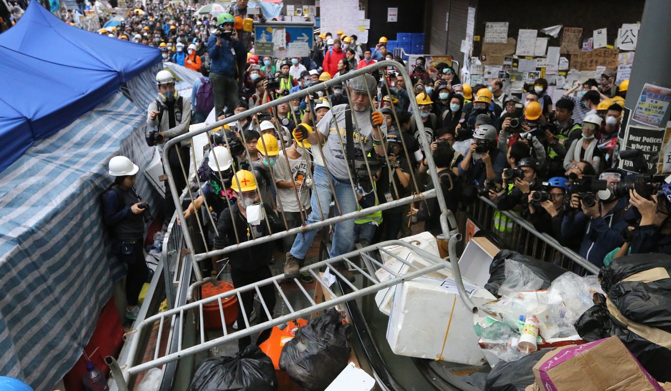 An Occupy protester tries to set up barricades to block the escalators leading to the government headquarters, on December 1, 2014. Photo: Sam Tsang