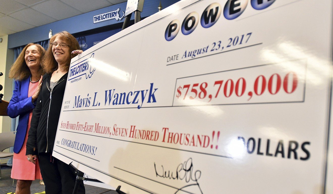 Mavis Wanczyk (in black), of Chicopee, Massachusetts, stands by a mock cheque of her winnings during a news conference where she claimed the $758.7 million Powerball prize at Massachusetts State Lottery headquarters on Thursday. Photo: AP