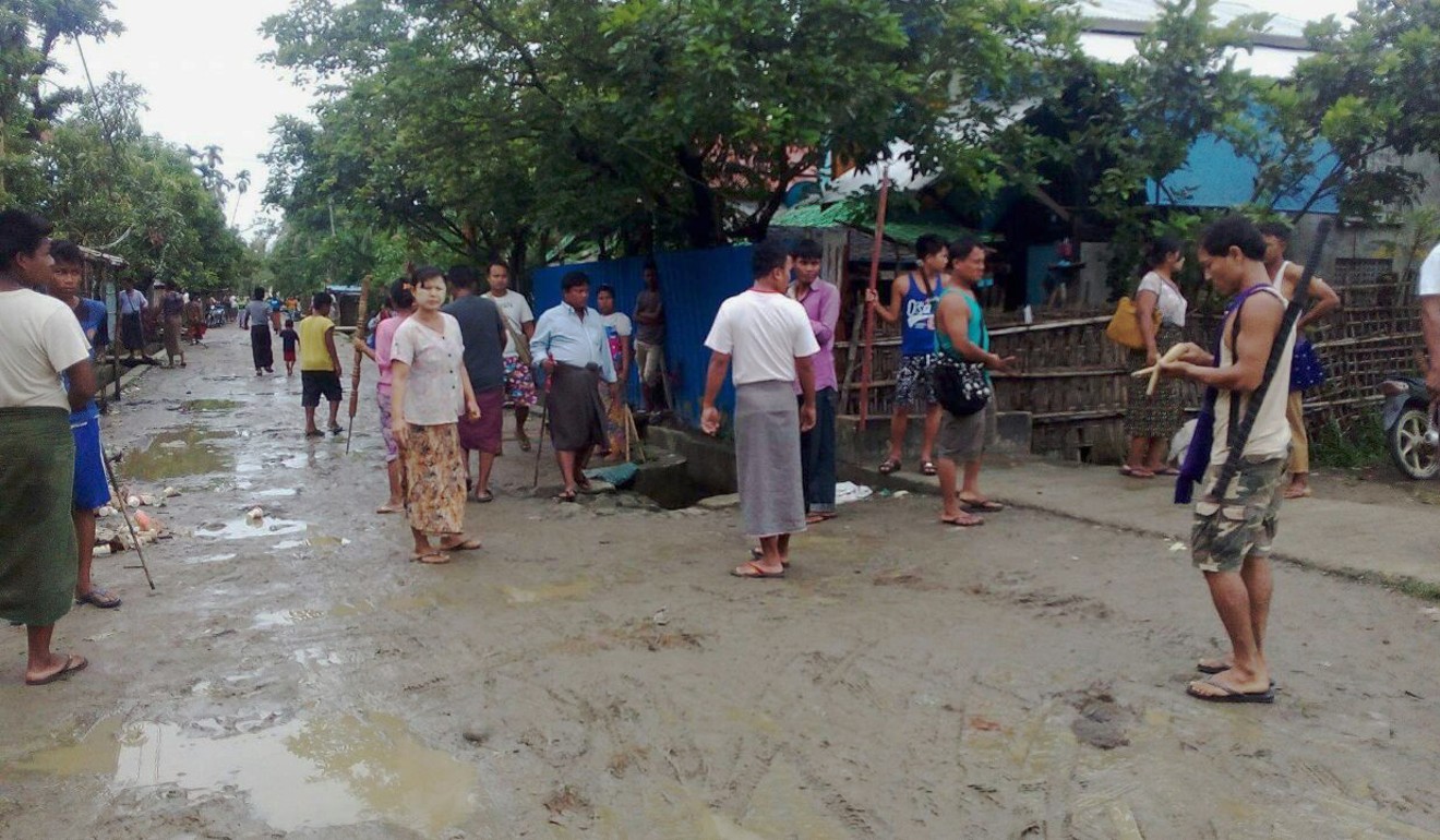 Ethnic Rakhines stand with sticks, a shotgun and blades as they guard their neighbourhood at the Yathae Taung township, in Rakhine State. Photo: AFP