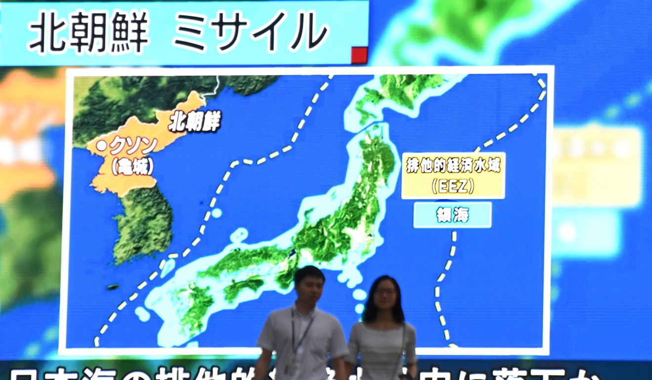 Tokyo pedestrians walk past a large screen displaying a map of Japan and the Korean Peninsula after North Korea launched a ballistic missile on July 4. Photo: AFP