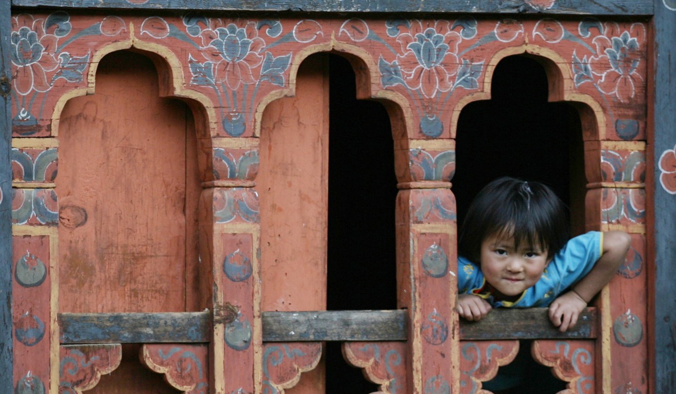 A Bhutanese girl looks through a traditionally made window in Thimphu in July 2009. Photo: Reuters
