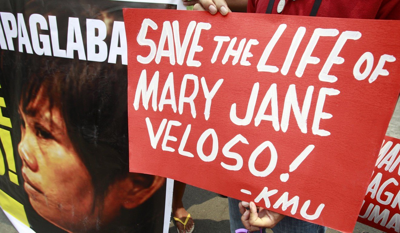Migrant rights activists carry placards urging the Philippine government to save Mary Jane Veloso, a migrant facing execution in Indonesia. Photo: Reuters