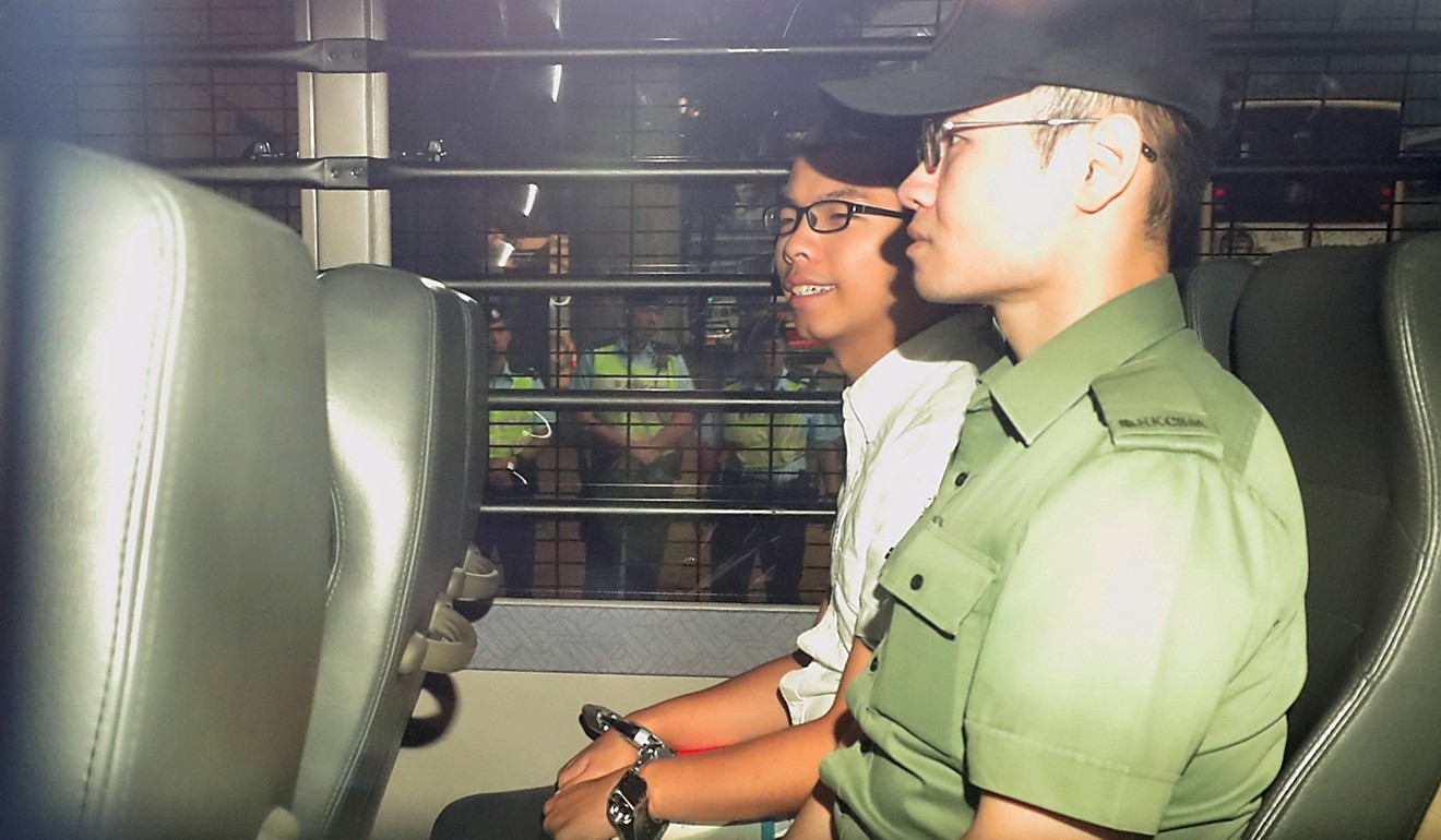 Joshua Wong is escorted by prison officers after the jail sentence was handed down. Photo: Handout
