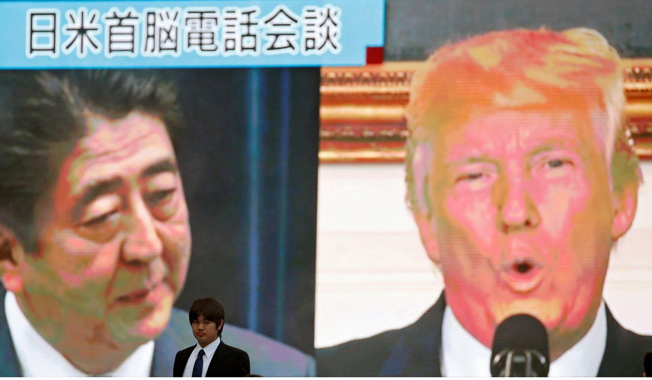 A man walks past a street monitor showing Japan's Prime Minister Shinzo Abe and US President Donald Trump in Tokyo. Photo: Reuters