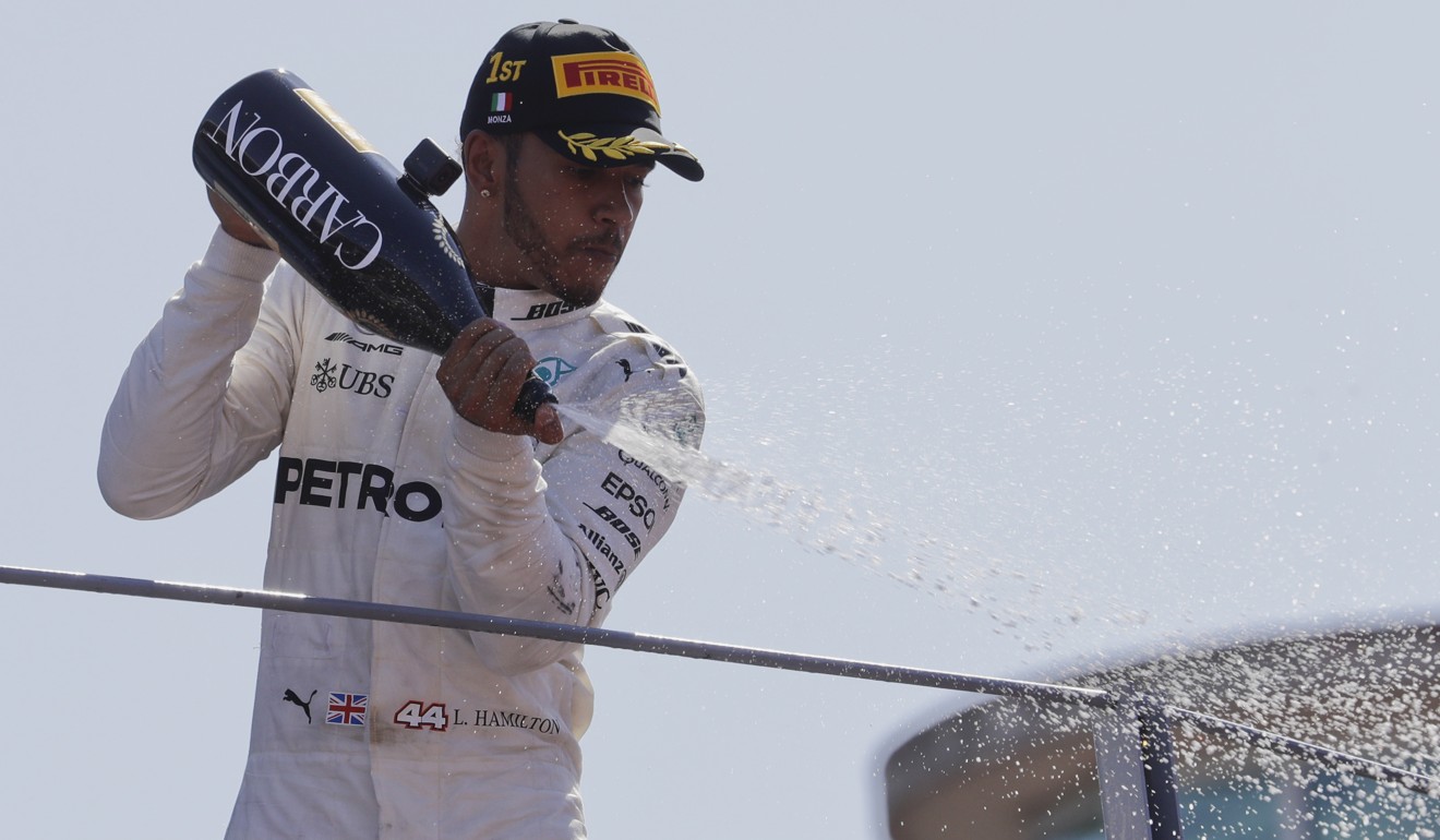 Hamilton sprays champagne on the podium. Photo: AP