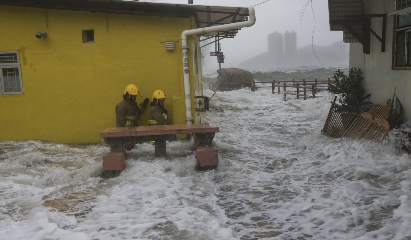 Firemen wade through strong waves in Lei Yue Mun as Typhoon Hato rages. Photo: Sam Tsang