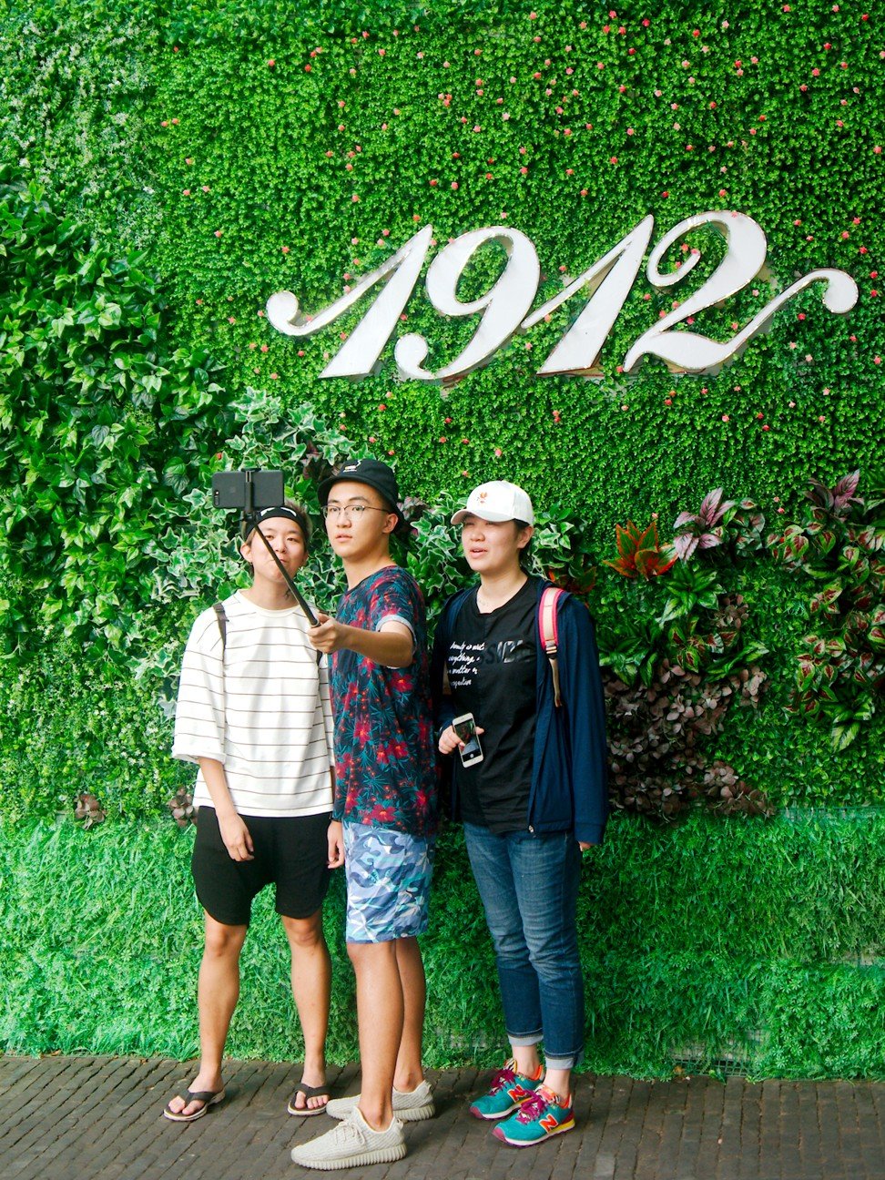 Tourists pose for selfies at the 1912 nightlife district in Nanjing. Photo: Stuart Heaver