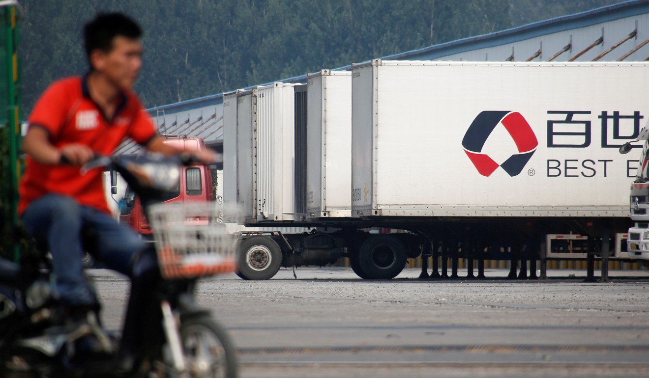 A man rides an electric scooter past a distribution hub of the Chinese logistics company Best Inc in Beijing on June 27, 2017. Photo: Reuters