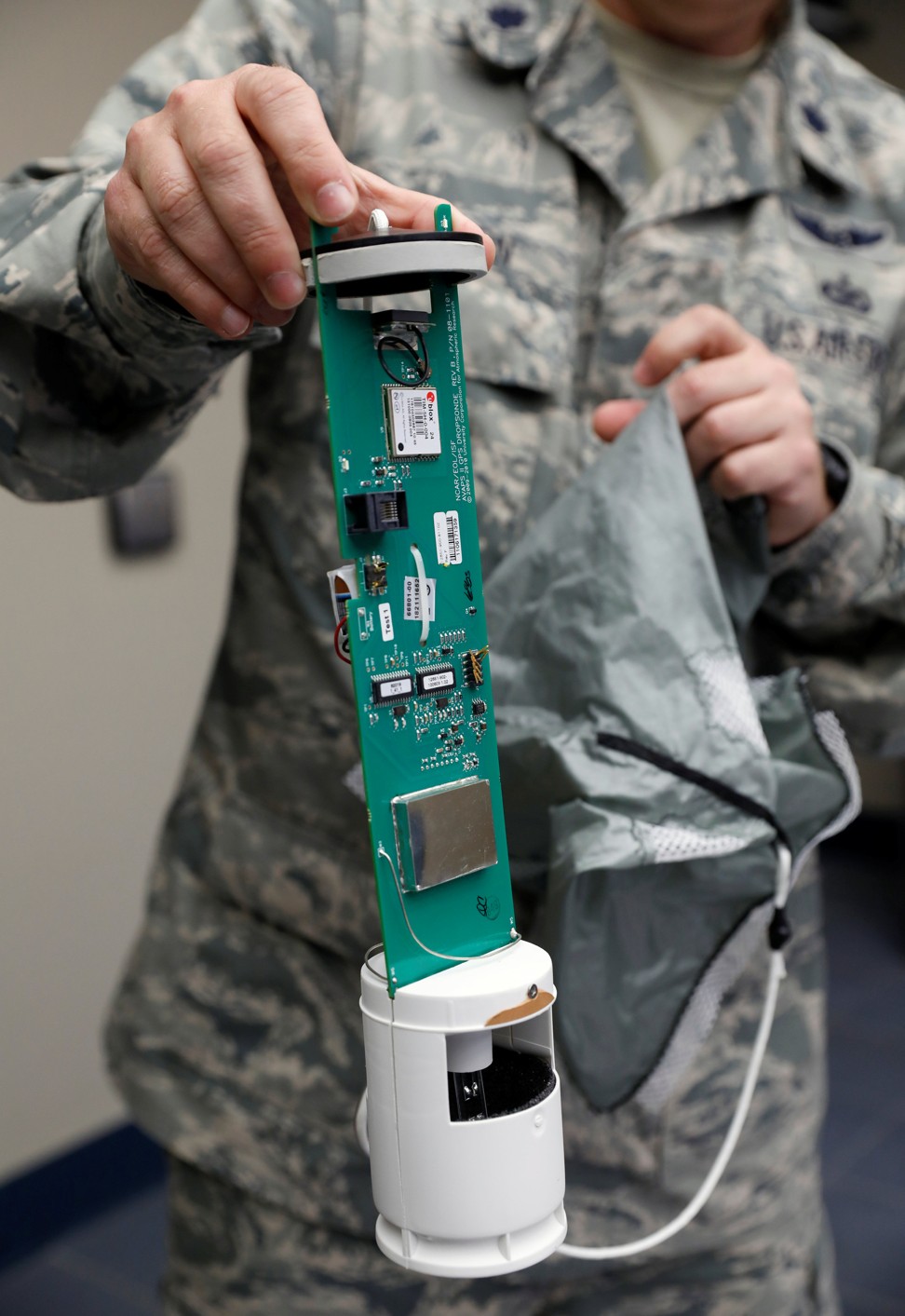 A US Air Force Reserves officer shows the inner workings of a dropsonde, a device dropped from planes to monitor meteorological data in a hurricane. Photo: Reuters