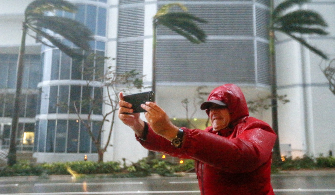 A nan tries to take a photo in the middle of Hurricane Irma. Photo: EPA
