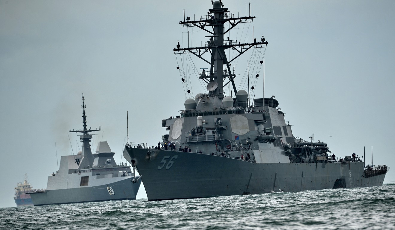The guided-missile destroyer USS John S. McCain, with a hole on its portside after a collision with an oil tanker, is escorted by Singapore Navy RSS Intrepid. Photo: AFP