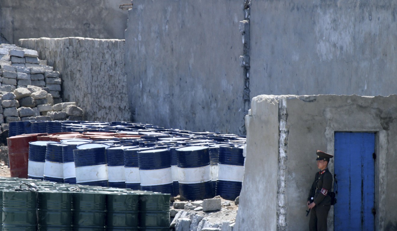 A North Korean soldier stands guard near oil barrels stocked up in Sinuiju in North Korea. Photo: AP