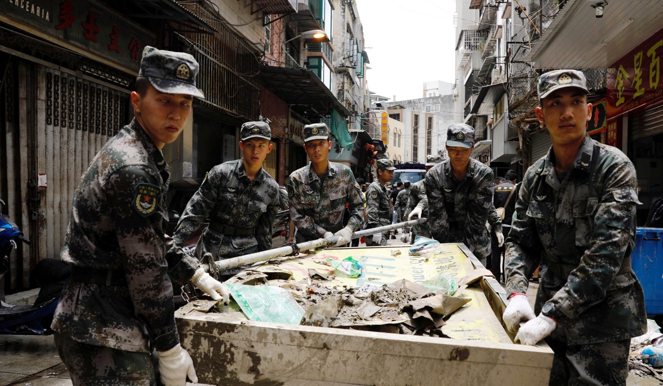 Soldiers from the People's Liberation Army clean debris left after Typhoon Hato struck Macau on August 25. Photo: Reuters