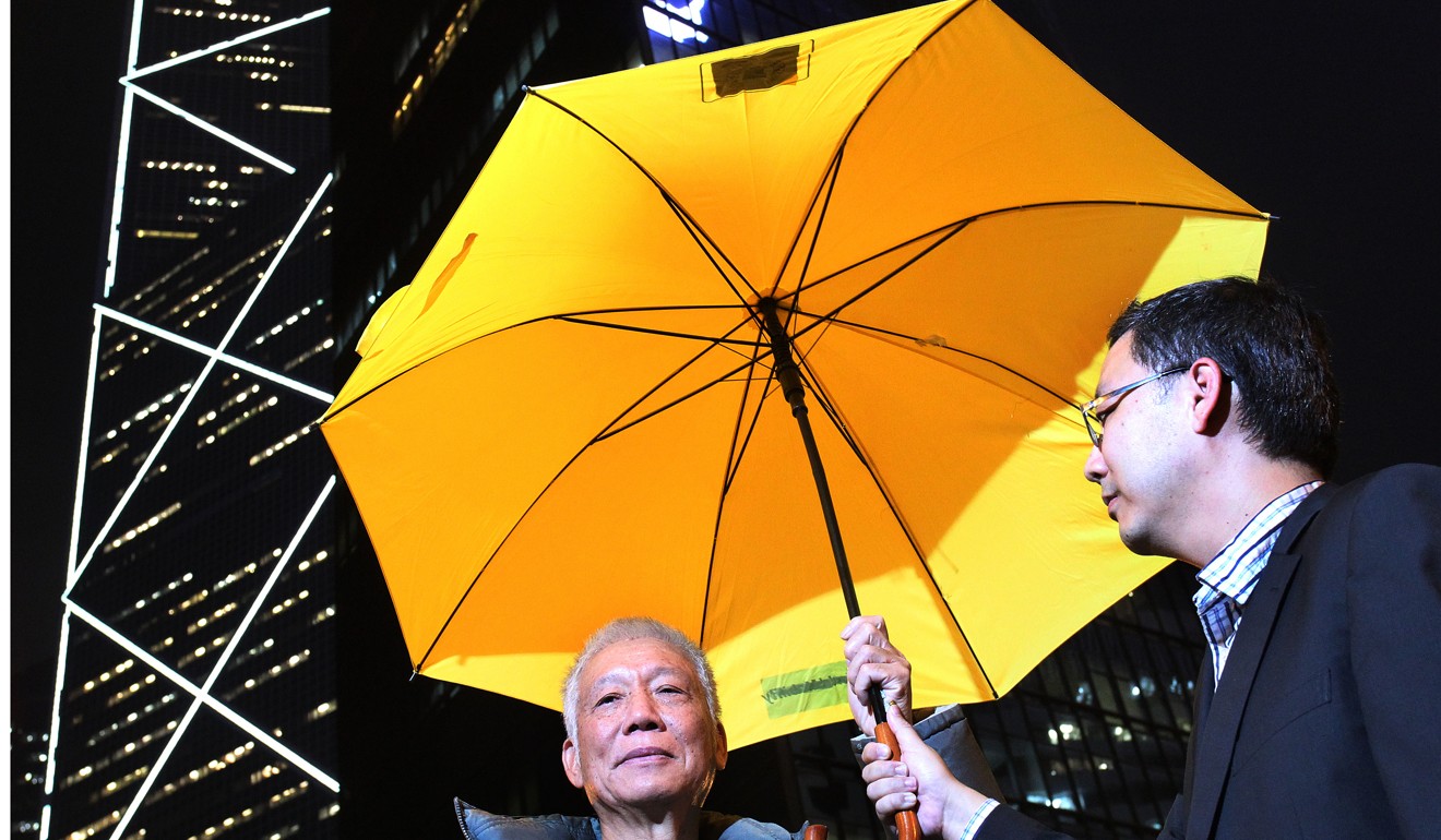 Occupy co-founder Reverend Chu Yiu-ming (left) and his son Daniel Chu Muk-wah under a yellow umbrella – a symbol of the pro-democracy movement. Photo: May Tse