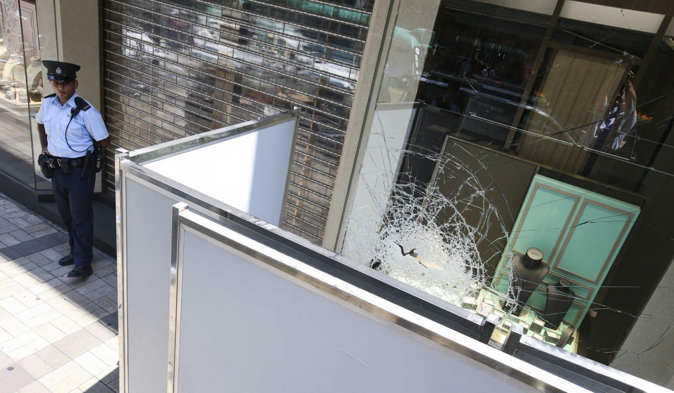 Police officers investigate the scene at Chow Sang Sang Jewellery shop in Tsim Sha Tsui. Photo: David Wong