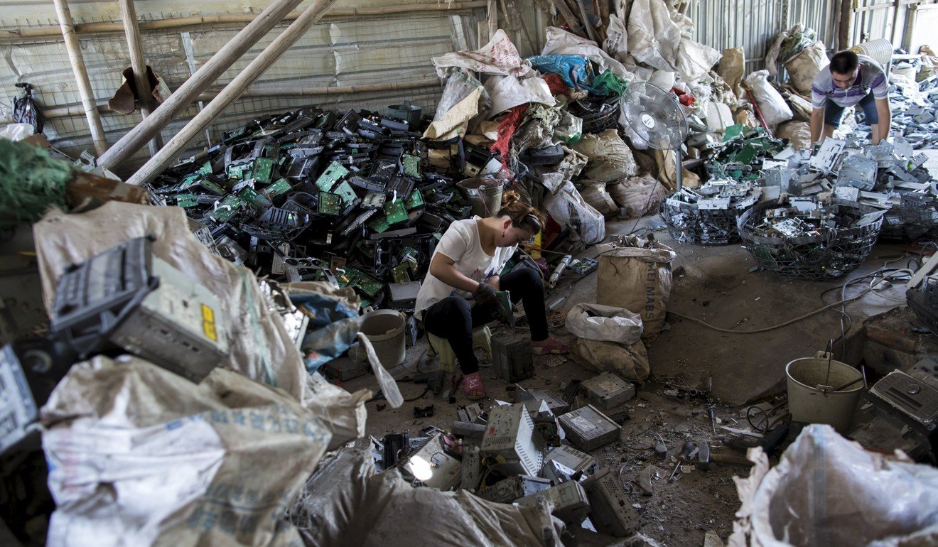 A worker recycles CD players at a workshop in Guiyu in June 2015. Photo: Reuters
