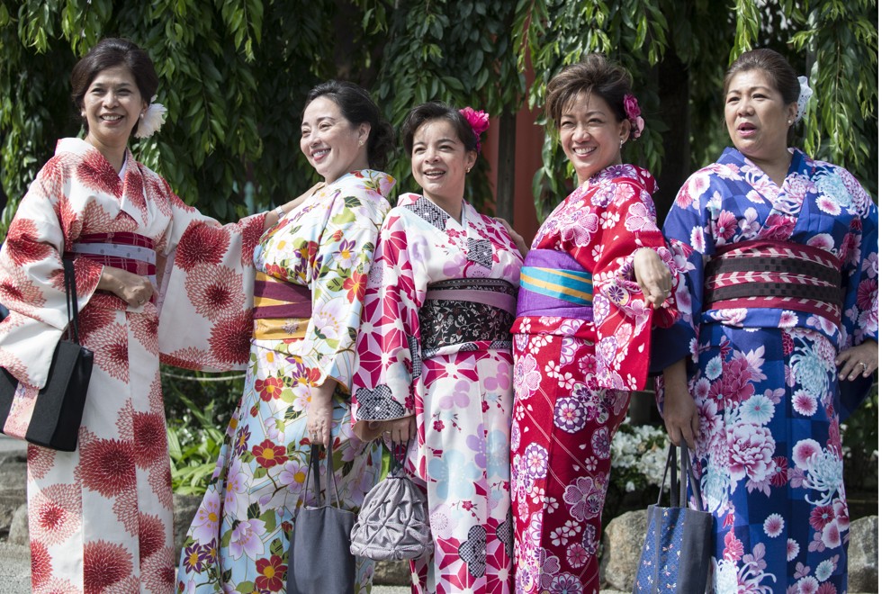 Middle-aged Chinese women pose in kimonos at a temple in Asakusa, Tokyo.