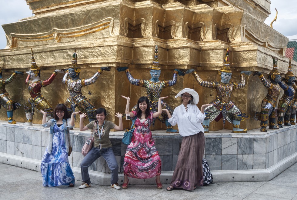 Chinese tourists pose in front of Bangkok’s Emerald Buddha Temple.