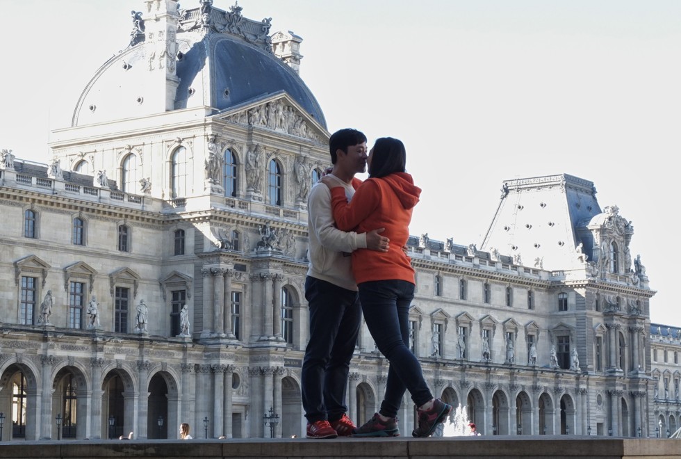 A couple kiss in front of the Louvre, in Paris, Europe’s top destination for Chinese.